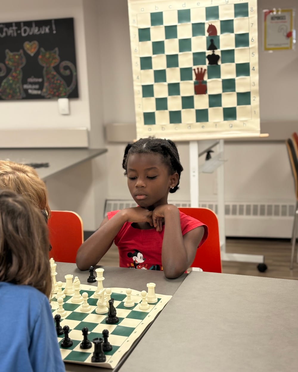 Jeune joueuse concentrée devant son échiquier
